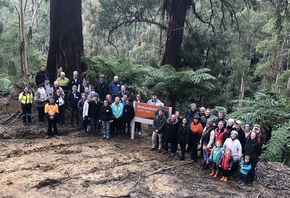 Picture of community groups in front of the Brataualung Forest Park sign